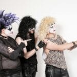 Troje muzyków glam rock w mocnym makijażu sceniczny we wnętrzu