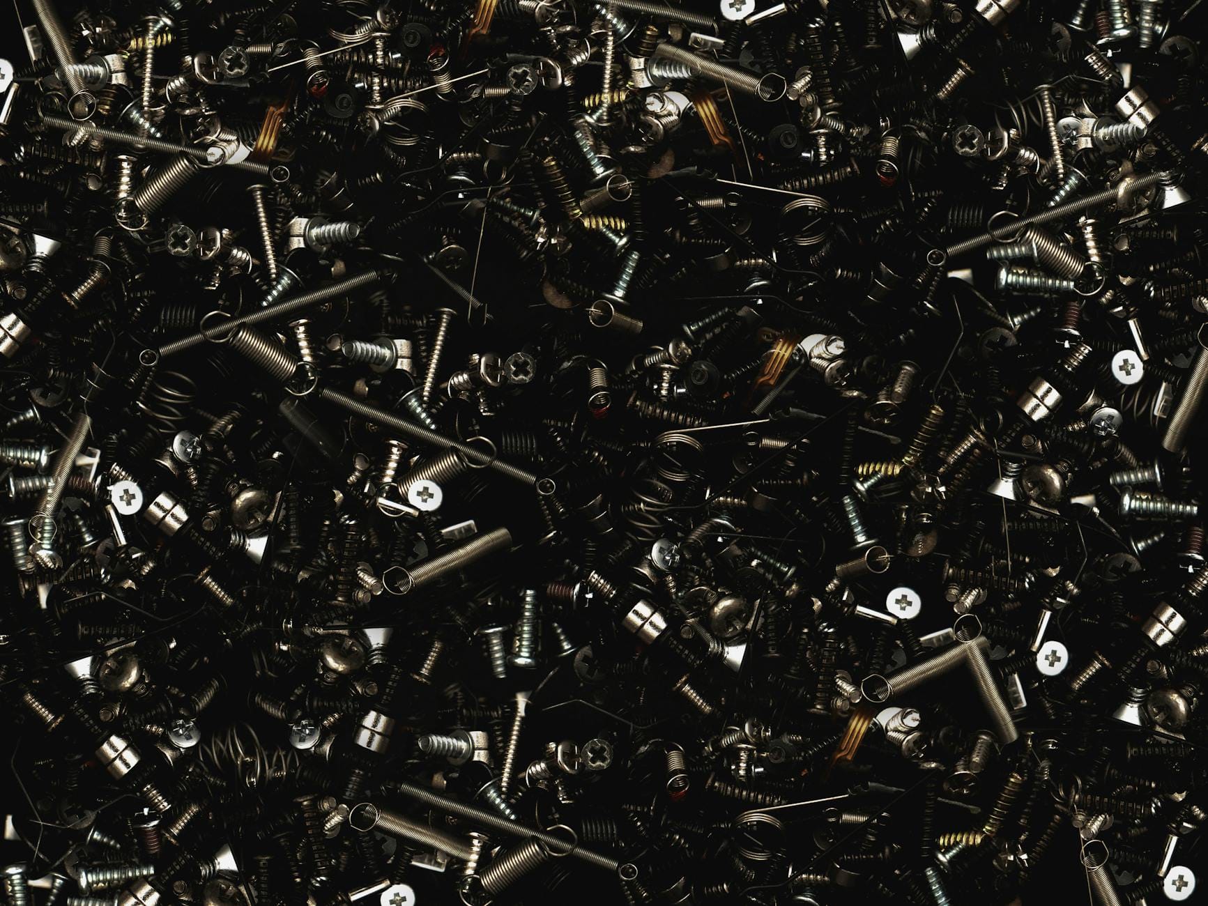 Zbliżenie na posegregowane metalowe śruby i śruby z nakrętkami