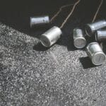 Puste puszki związane sznurkiem leżące na asfalcie