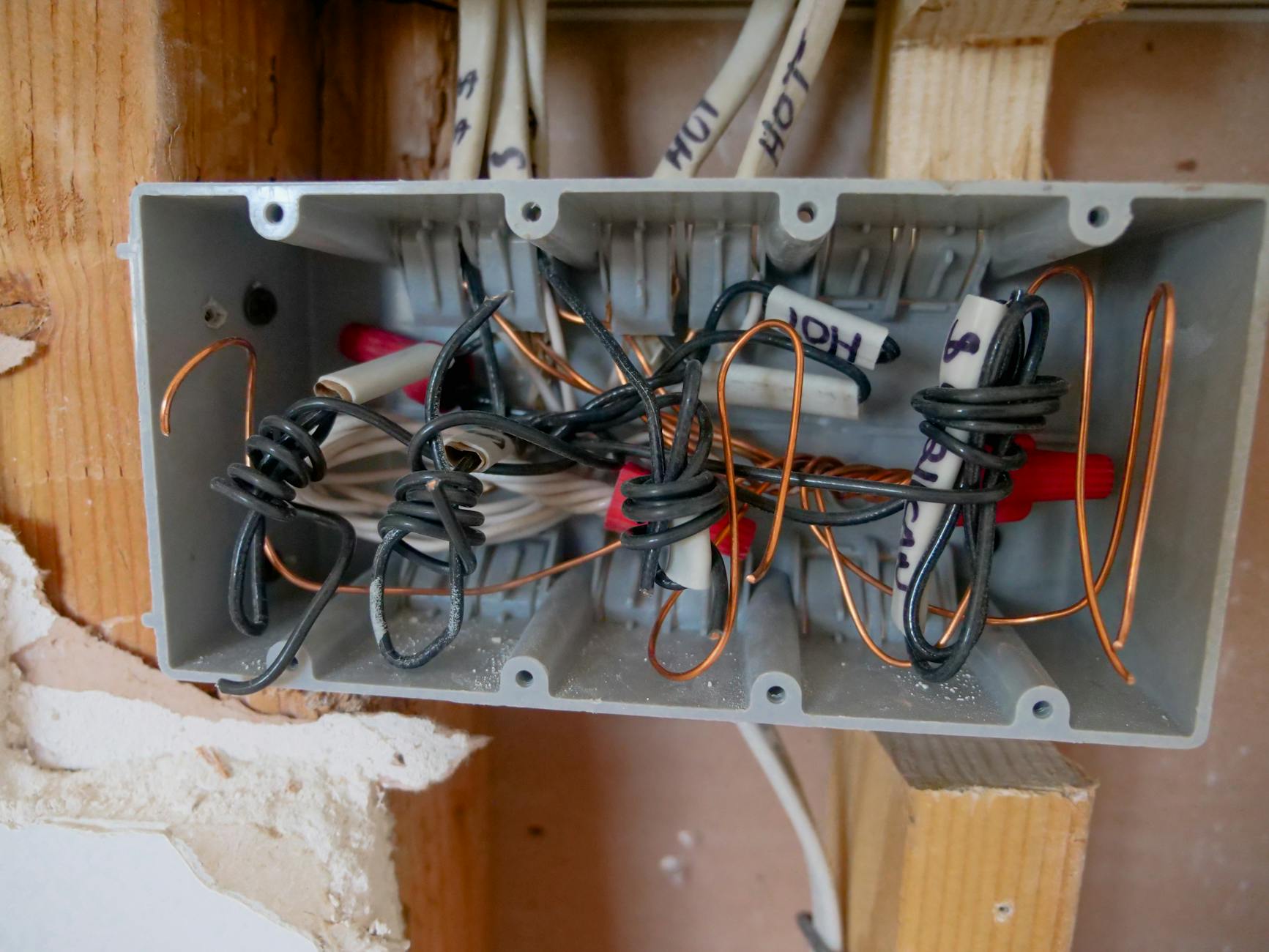 Otwarte rozdzielnice elektryczne z poplątanymi przewodami