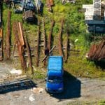 Złom stalowy na złomowisku z niebieskim busem z lotu ptaka