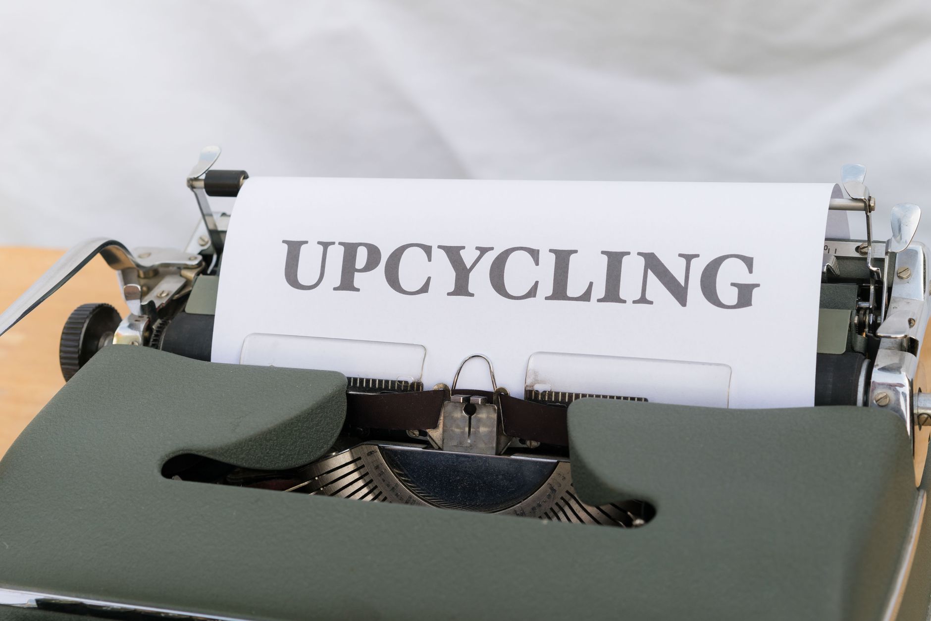 Zbliżenie na starą maszynę do pisania z napisem UPCYCLING na kartce