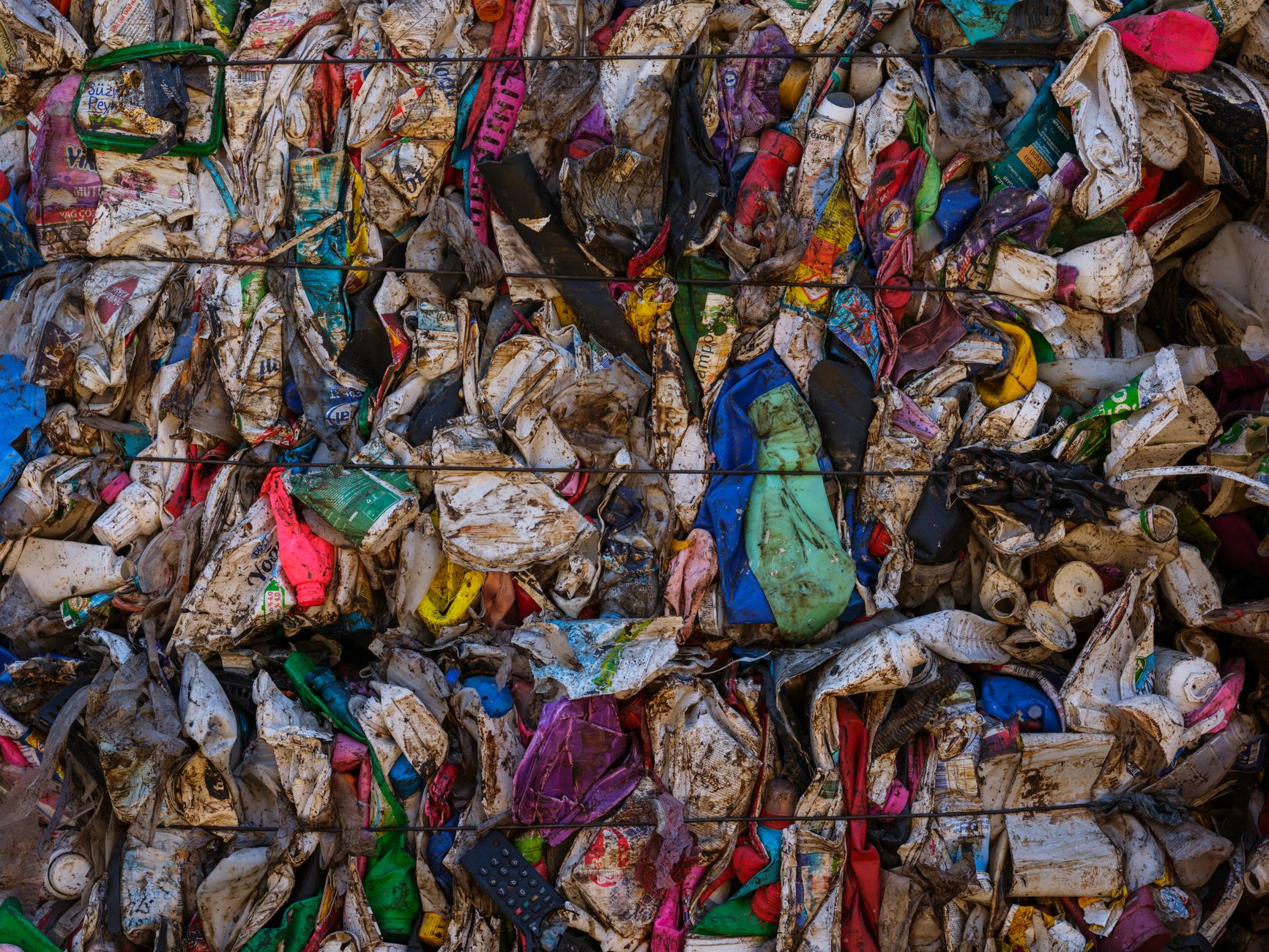 Czy recykling zawsze ma sens? Kiedy lepsza jest naprawa albo ponowne użycie Ściana sprasowanych kolorowych odpadów plastikowych w belach